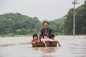 Kakek terobos banjir demi antar tiga cucu perempuan ke sekolah. (Foto: Shanghaiist)