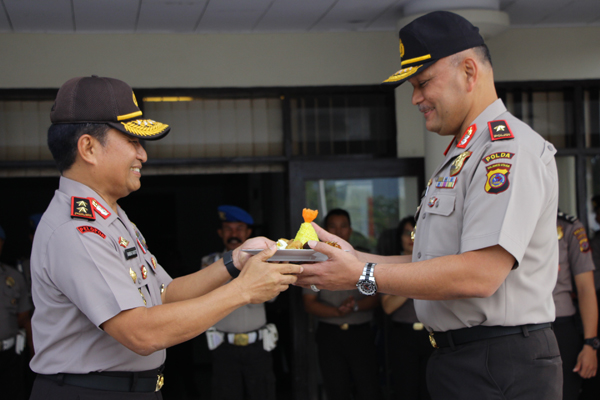 Kapolda Sulut Drs Bambang Waskito menyerahkan kue tumpeng kepada Wakapolda Brig Jen Pol Drs Refdi Andri MSi saat syukuran kenaikan pangkat Wakapolda di Mapolda Sulut, Senin (27/3/2017. (foto hms Polda Sulut)