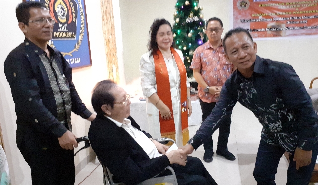 Penyerahan Diakonia Natal oleh Ketua PWI Sulut Voucke Lontaan kepada Sesepuh Wartawan Sulut Simon Petrus Goni.