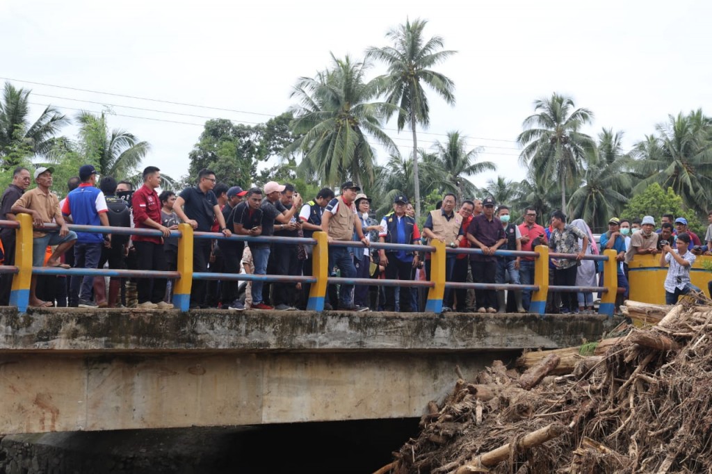 Material yang terbawa arus sungai di salah satu jembatan membuat air meluap dan menghantam rumah warga