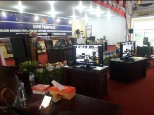 Tampak Bupati Vonnie Panambunan terlihat pada layar TV saat mengikuti rapat paripurna LKPJ bersama DPRD Minut