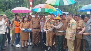 RESMIKAN: Bupati Vonnie Panambunan melakukan pengguntingan pita peresmian jembatan kuwil.