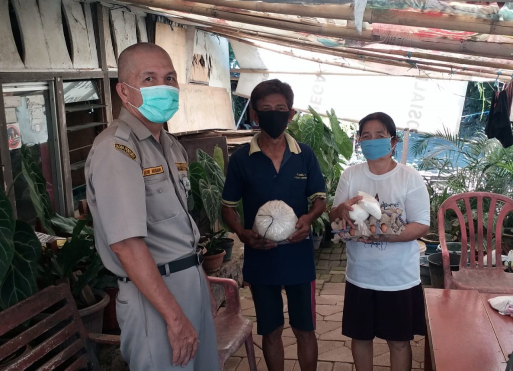 Penyerahan bantuan di rumah salah satu keluarga