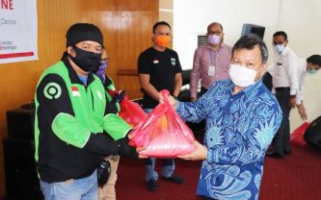 Direktur Umum Bank SulutGo Revino Pepah saat menyerahkan bantuan bahan natura pada Ojek Online beberapa waktu lalu