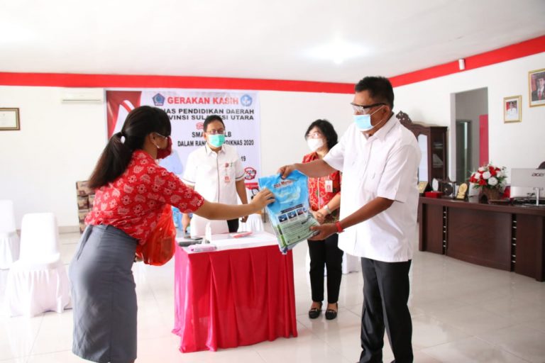 Gubernur Olly Dondokambey SE saat menyerahkan bantuan paket sembako bagi siswa kurang mampu