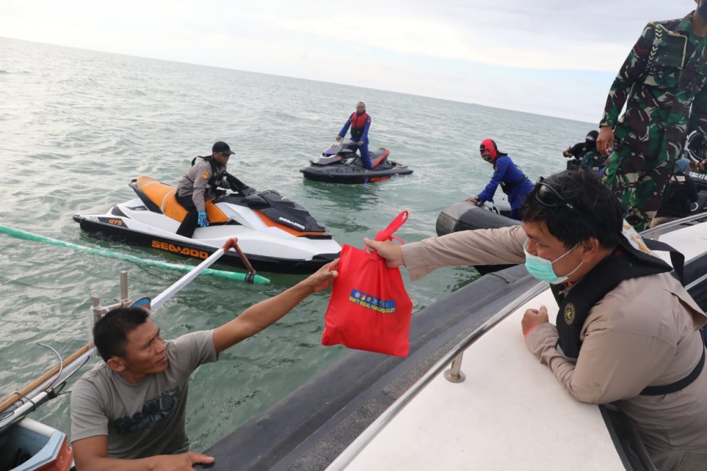 Wakil Gubernur Sulut Drs Steven OE Kandouw saat menyerahkan paket Sembako pada Nelayan di tengah laut