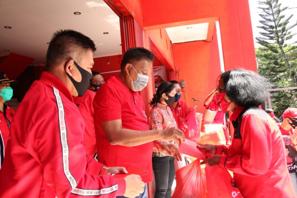 Ketua DPD PDI Perjuangan Sulut Olly Dondokambey SE menyerahkan paket sembako pada pengurus PAC dan Ranting se-Sulut