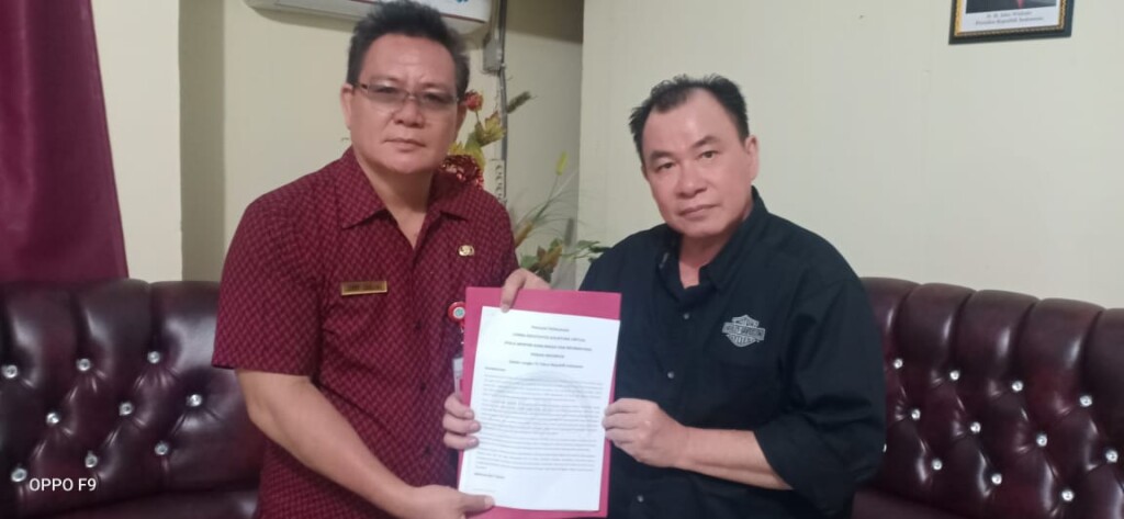 Ketua Harian PINKAN Indonesia Jopy Rori menyerahkan Juklak Lomba Kolintang Virtual kepada Kadis Kebudayaan Jenry Sualang SPd MAP di ruang kerja.