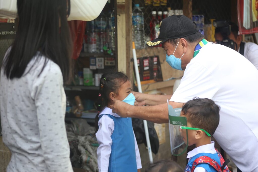 Ayahanda Max Lomban melalaikan masker pada anak PAUD saat ke tempat lokasi kegiatan