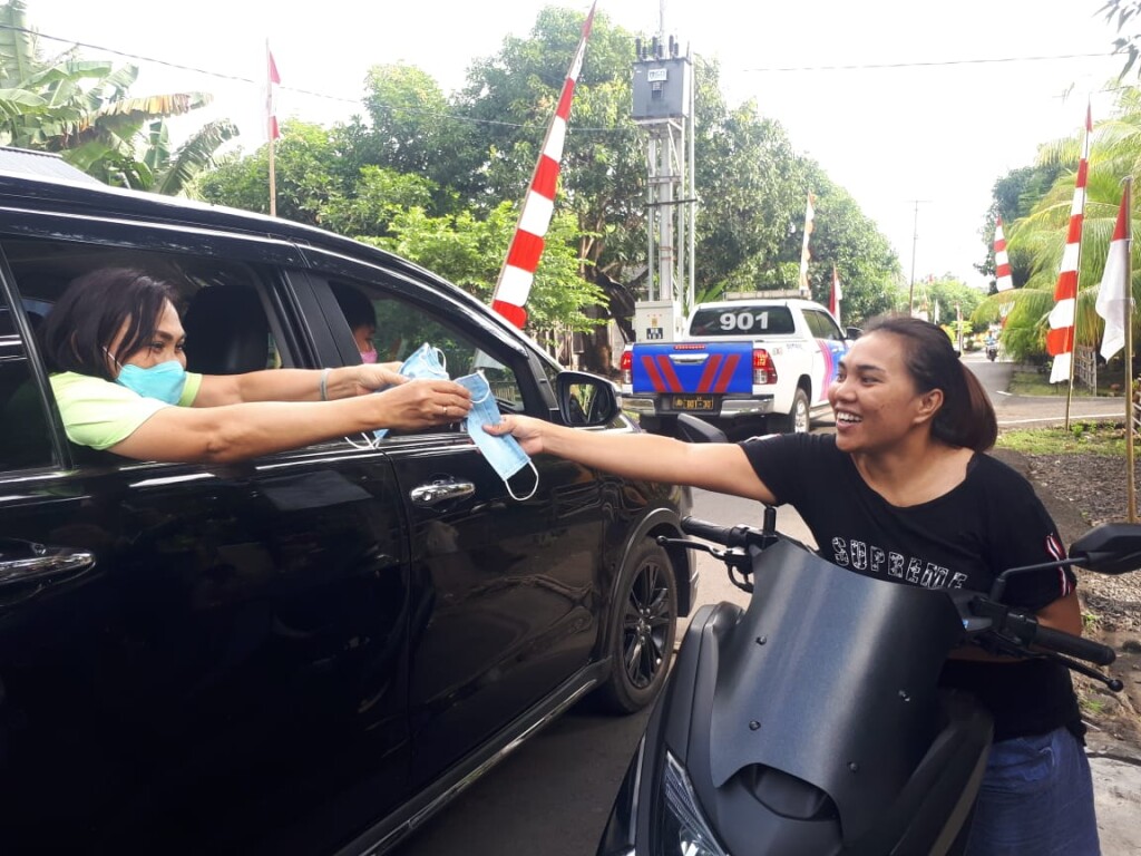 Tak Gunakan Masker, Ibu Khouni Lomban Rawung bagi-bagi masker kepada pengguna jalan