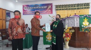 Calon Bupati Minut Joune Ganda didampingi Ketua Komisi 3 DPRD Sulut Berty Kapojos tampak menyerahkan bantuan Hibah lahan atas pembangunan TK/PAUD GMIM Yordan Likupang Kampung Ambong.