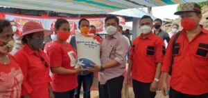 Pjs. Bupati Minut Clay Dondokambey menyerahkan secara simbolis bantuan sosial Beras PKH kepada warga.