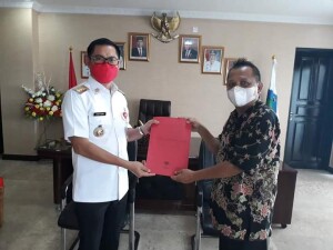 Bupati Joune Ganda saat menyerahkan SK TAB bidang Komunikasi dan Informasi Publik kepada Djemie Karongkong, S.Sos M.Pd