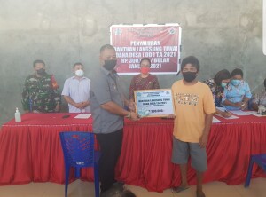 Camat Kalawat Alexander Warbung menyerahkan BLT secara simbolis kepada kelurga penerima manfaat.