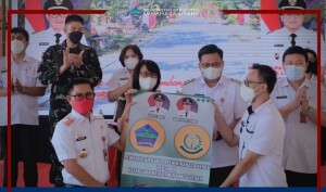 Bupati Joune Ganda saat memberikan secara simbolis baliho kepada Hukum Tua Roli Rorong.