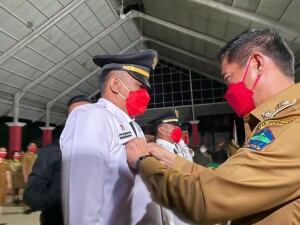 Bupati Joune Ganda memasang tanda nama kepada Camat Kalawt Asriyadi Lalompoh.