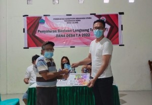 Kumtua Lilang Frangky Roli Rorong saat menyerahkan bantuan langsung tunai kepada warga.