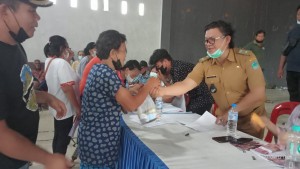 Kumtua Fredrik Sumakud saat menyerahkan BLT kepada keluarga penerima manfaat