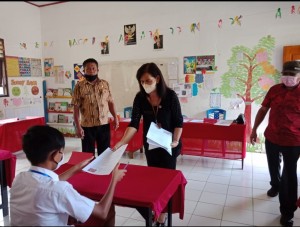 Kepala Bidang PTK Rini Paulus saat membagikan soal ujian sekolah di SD Inpres Wasian.
