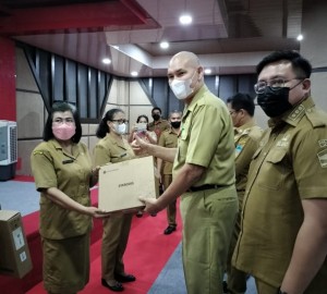 Pjs. Sekda Rivino Dondokambey menyerahkan secara simbolis kepada kepala sekolah.