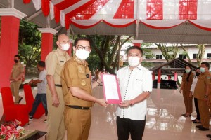 Penyerahan SK nomor 303 oleh Bupati Joune Ganda kepada Ketua Umum LPPD Minahasa Utara Denny Kamlon Lolong yang juga ketua DPRD Minut.