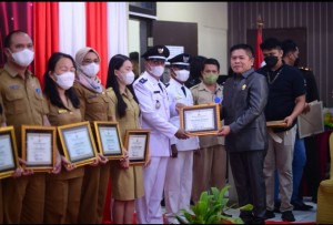 Ketua DPRD Minut Denny Kamlon Lolong menyerahkan Piagam Penghargaan dari Polri kepada Rommy Charles Lopo Penjabat Kumtua Desa Wori.