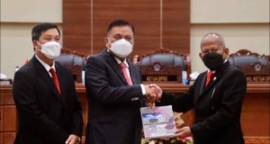 Anggota BPK RI Pius Lustrilanang menyerahkan dokumen  LHP BPK RI kepada Pemprov Sulut dengan hasil WTP melalui Rapat Paripurna DPRD Sulut, Jumat (13/05/2022).
